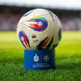 Piłka PKO Bank Polski Ekstraklasa na niebieskim postumencie. Zbliża się koniec sezonu, a to oznacza, ile kolejek do końca ekstraklasy pozostało do rozstrzygnięcia.