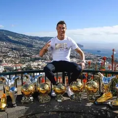 Cristiano Ronaldo z pięcioma złotymi piłkami, symbolizującymi jego sukcesy.