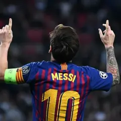 Piłkarz FC Barcelona Lionel Messi z podniesionymi rękami i numerem 10 na plecach.