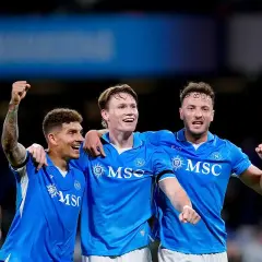 Trzech piłkarzy Napoli świętuje zwycięstwo nad Hellas Verona. Radość na twarzach zawodników.