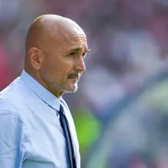 Łysy mężczyzna z wąsami, ubrany w błękitną koszulę i krawat, w skupieniu obserwuje boisko. To trener Juventusu.
