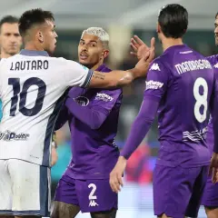 Intensywna wymiana zdań między Lautaro (Inter) a zawodnikiem Fiorentiny podczas meczu. Sędzia w pobliżu.