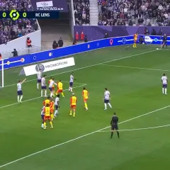 Mecz Toulouse FC - RC Lens. Piłkarze w białych i żółtych strojach szykują się do akcji pod bramką.