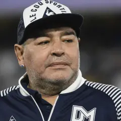 Diego Maradona na co zmarł? Ikona futbolu w czapce z daszkiem i sportowej kurtce.