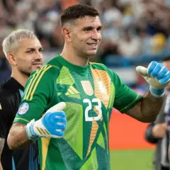 Bramkarz reprezentacji Argentyny w zielonej koszulce z numerem 23, z dumą pozuje na boisku.