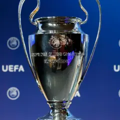 Puchar Ligi Mistrzów UEFA na niebieskim tle z logo UEFA.