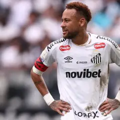 Neymar w białej koszulce Santos FC, z opaską kapitana na ramieniu, na tle trybun.