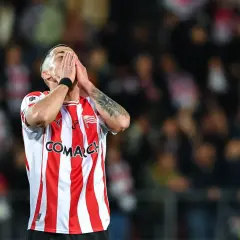 Piłkarz Cracovii w geście rozpaczy, w koszulce w biało-czerwone pasy, podczas meczu składy: Cracovia – Pogoń Szczecin.