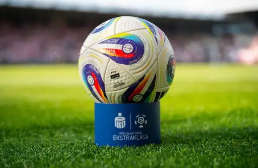 Piłka PKO Bank Polski Ekstraklasa na niebieskim postumencie. Zbliża się koniec sezonu, a to oznacza, ile kolejek do końca ekstraklasy pozostało do rozstrzygnięcia.