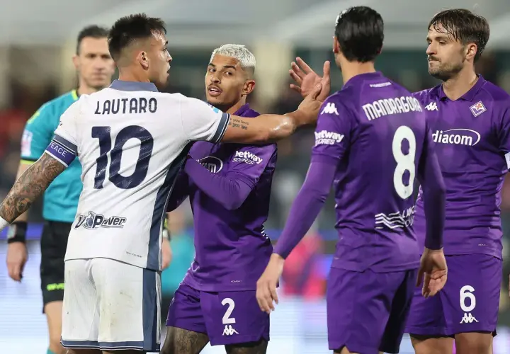 Intensywna wymiana zdań między Lautaro (Inter) a zawodnikiem Fiorentiny podczas meczu. Sędzia w pobliżu.