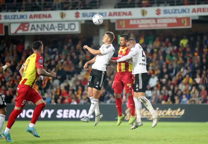 Piłkarze walczą o piłkę w powietrzu. Emocje na boisku, jak podczas ważnych ekstraklasa transfery.