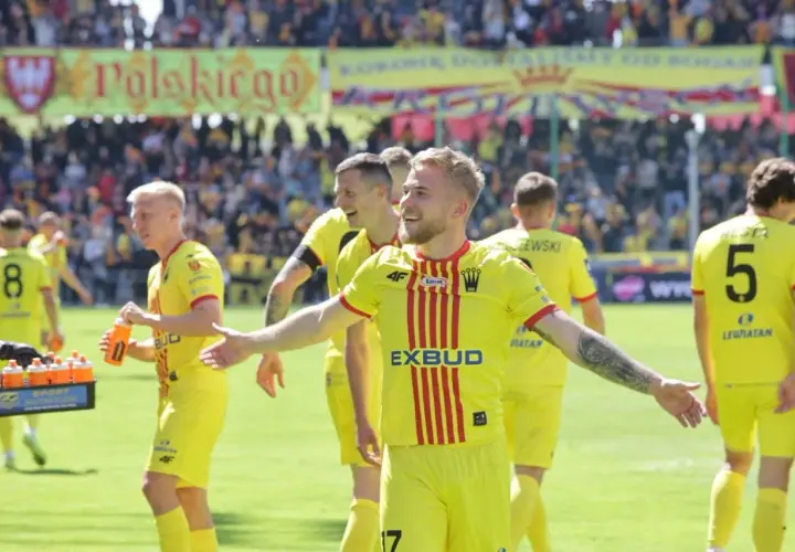 Piłkarze Korony Kielce w żółtych strojach świętują po meczu z Jagiellonią Białystok. Radość na twarzach zawodników.