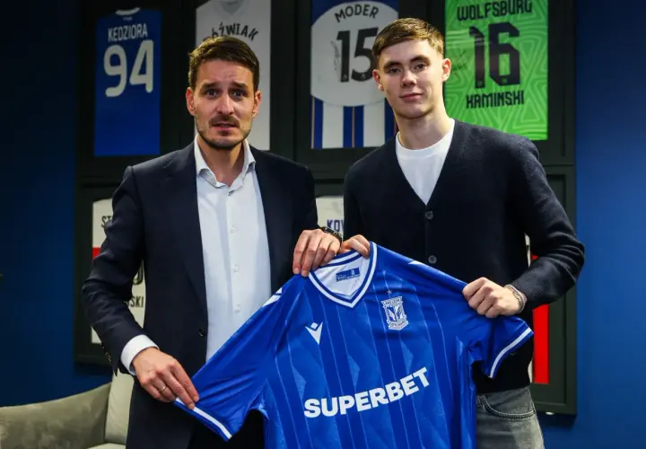 Dwóch mężczyzn prezentuje niebieską koszulkę Lecha Poznań. To kolejny z ekscytujących lech poznan transfery.