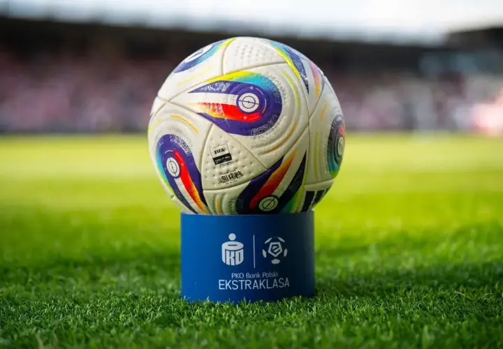 Piłka PKO Bank Polski Ekstraklasa na niebieskim postumencie. Zbliża się koniec sezonu, a to oznacza, ile kolejek do końca ekstraklasy pozostało do rozstrzygnięcia.
