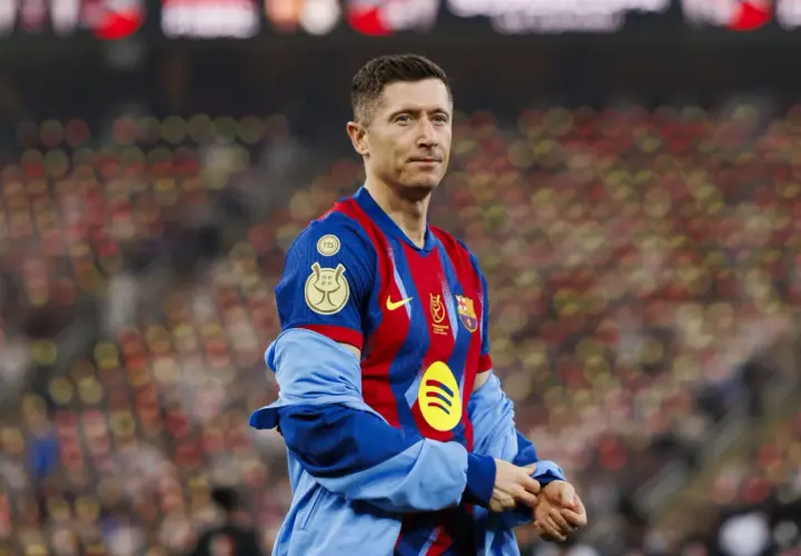 Robert Lewandowski, jeden z najlepiej zarabiających piłkarzy, w koszulce FC Barcelony na tle rozmazanych trybun.