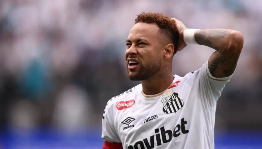 Neymar z grymasem na twarzy, trzymający się za głowę, sugeruje ból po kontuzji.