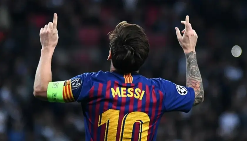 Piłkarz FC Barcelona Lionel Messi z podniesionymi rękami i numerem 10 na plecach.