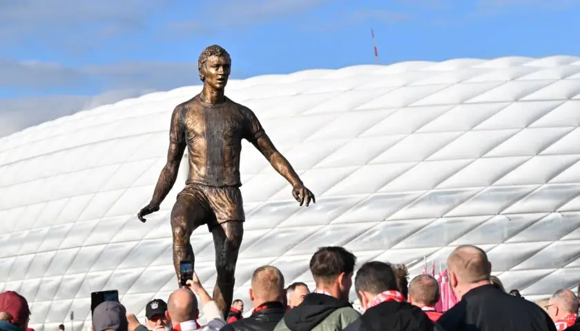 Pomnik piłkarza z Monachium przed stadionem. Fani robią zdjęcia.