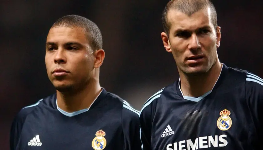 Ronaldo i Zidane, dwaj legendarni galacticos Realu Madryt, w ciemnych strojach meczowych.