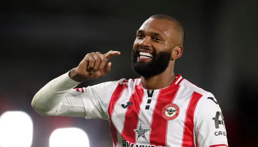 Uśmiechnięty Igor Thiago, piłkarz Brentford FC, pokazuje palcem w górę.