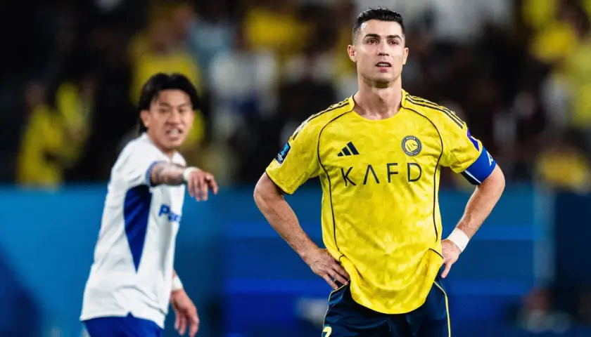 Cristiano Ronaldo w żółtej koszulce Al Nassr, zapatrzony w dal. Obok niego zawodnik w białej koszulce. To obrazek z życia ligi arabskiej, tabela wyników pewnie zaraz się pojawi.