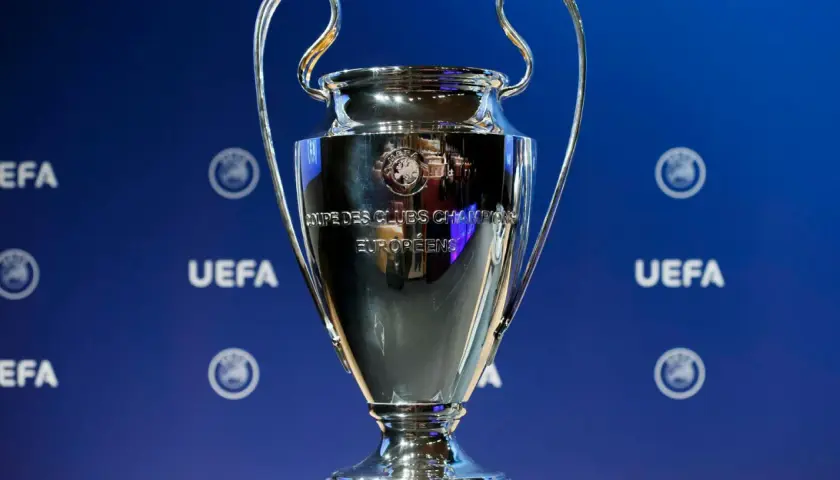 Puchar Ligi Mistrzów UEFA na niebieskim tle z logo UEFA.