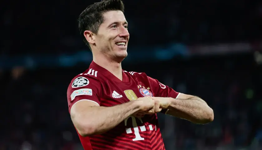 Robert Lewandowski, jeden z najlepszych króli strzelców Bundesligi, świętuje bramkę w czerwonej koszulce Bayernu Monachium.