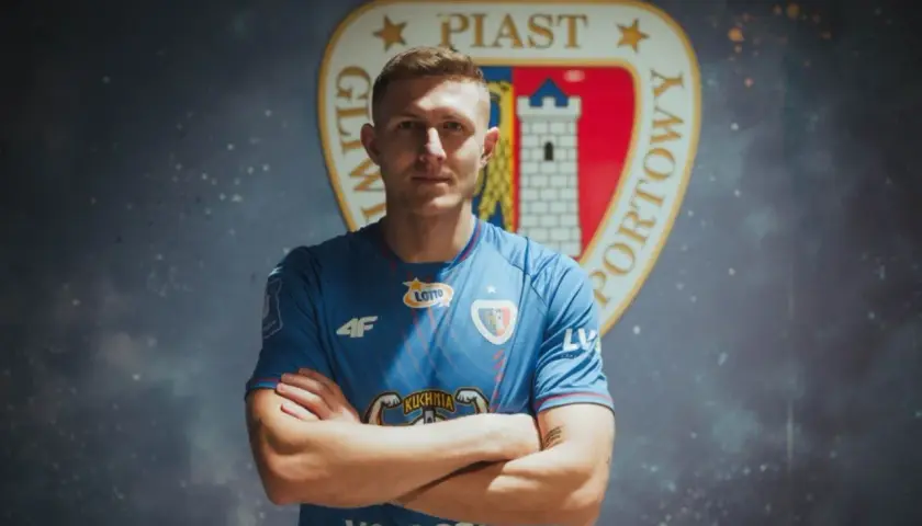 Piast Gliwice ogłasza nowe piast gliwice transfery. Młody piłkarz w niebieskiej koszulce z herbem klubu.