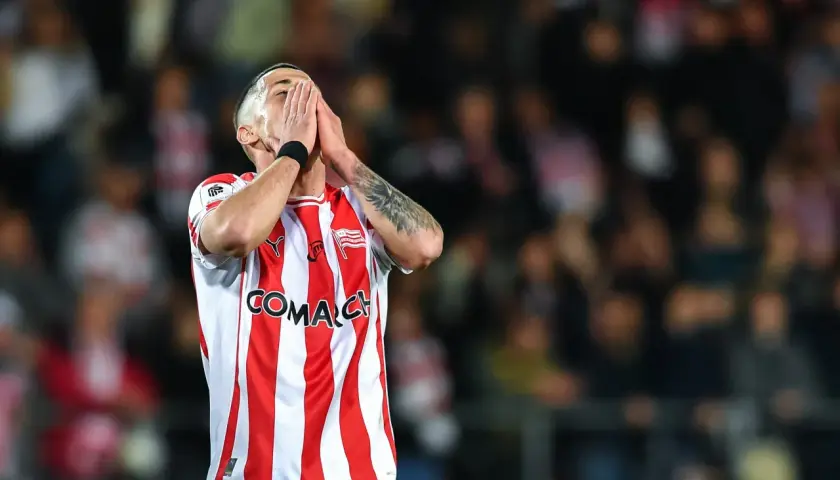 Piłkarz Cracovii w geście rozpaczy, w koszulce w biało-czerwone pasy, podczas meczu składy: Cracovia – Pogoń Szczecin.