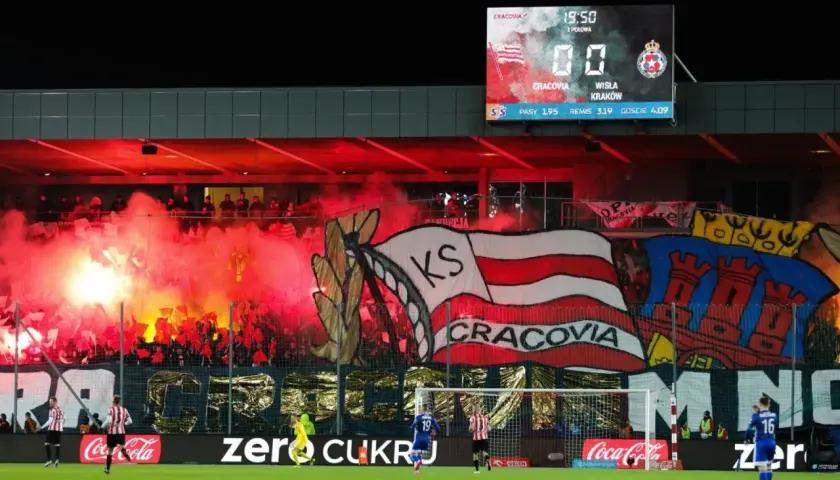 Oprawa meczowa najstarszego klubu piłkarskiego w Polsce. Kibice Cracovii odpalili race, tworząc czerwony dym i transparenty.