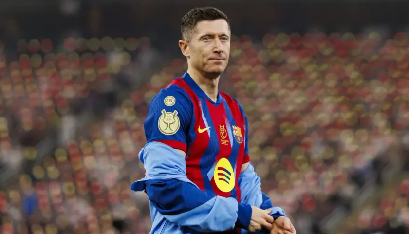 Robert Lewandowski, jeden z najlepiej zarabiających piłkarzy, w koszulce FC Barcelony na tle rozmazanych trybun.