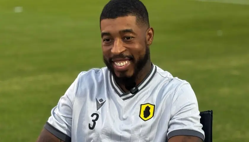 Uśmiechnięty piłkarz Kimpembe w jasnej koszulce z numerem 3 i herbem drużyny.