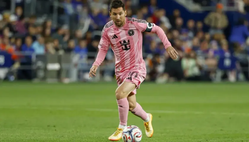 Lionel Messi w różowej koszulce Inter Miami drybluje piłką na boisku MLS.