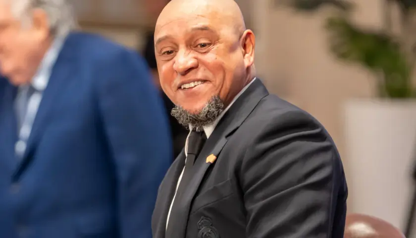 Roberto Carlos żyje i uśmiecha się szeroko, ubrany w elegancki garnitur z herbem Realu Madryt.