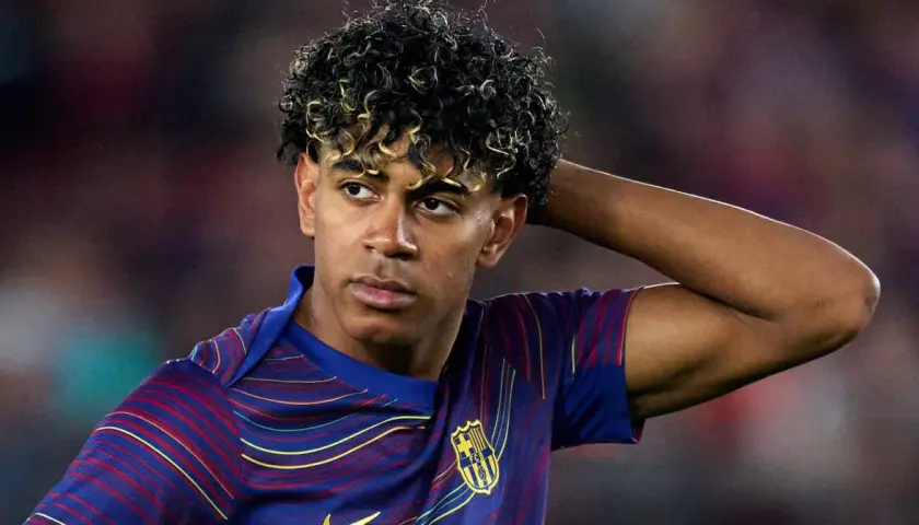 Lamine Yamal z FC Barcelony, zmartwiony po kontuzji, trzyma rękę za głową.