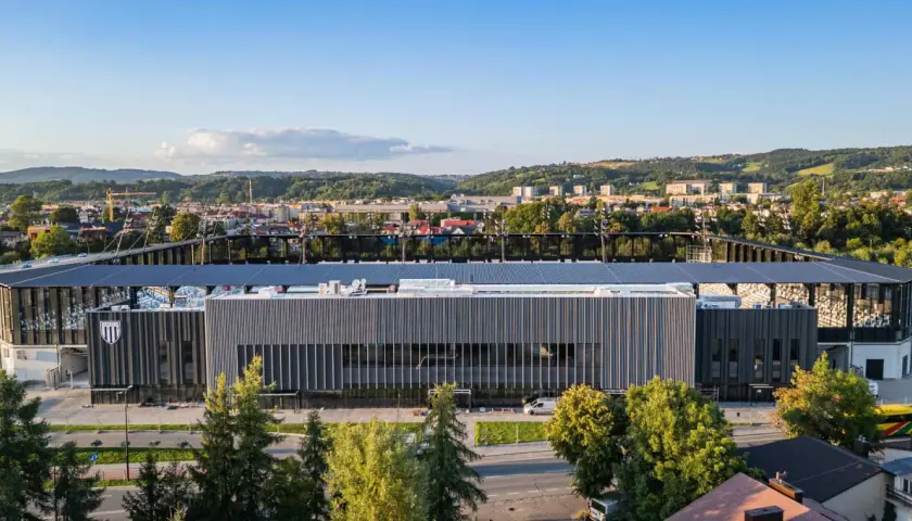Nowoczesny stadion Sandecji w Nowym Sączu, otoczony zielenią i górami, gotowy na nowe emocje.