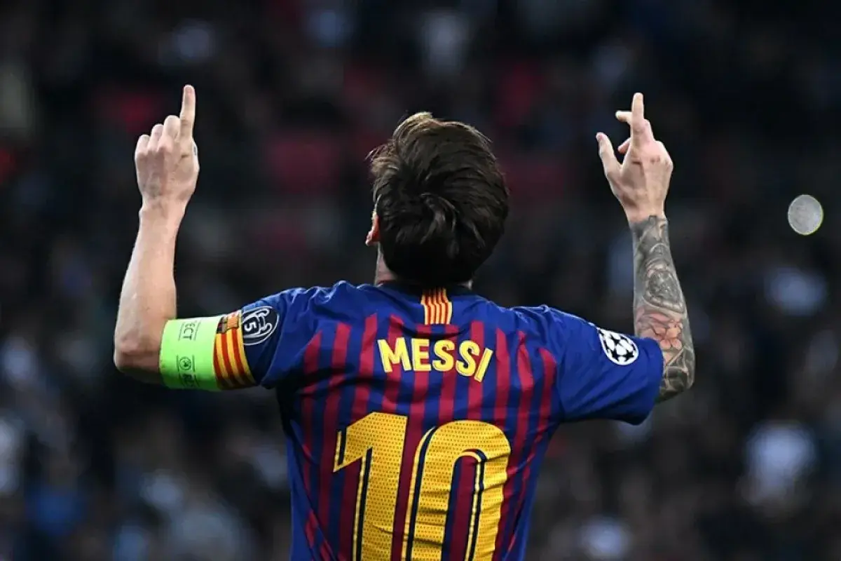 Piłkarz FC Barcelona Lionel Messi z podniesionymi rękami i numerem 10 na plecach.