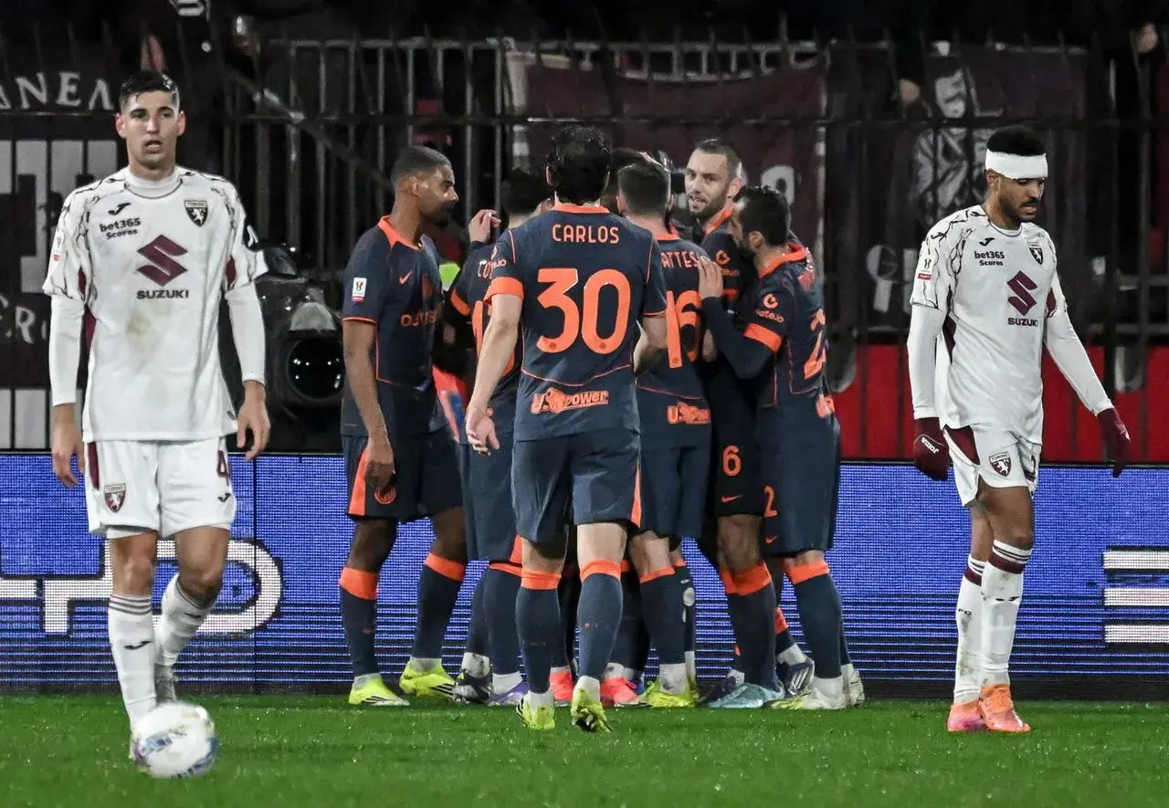 Piłkarze Interu Mediolan świętują bramkę, podczas gdy zawodnicy Torino FC patrzą zrezygnowani.
