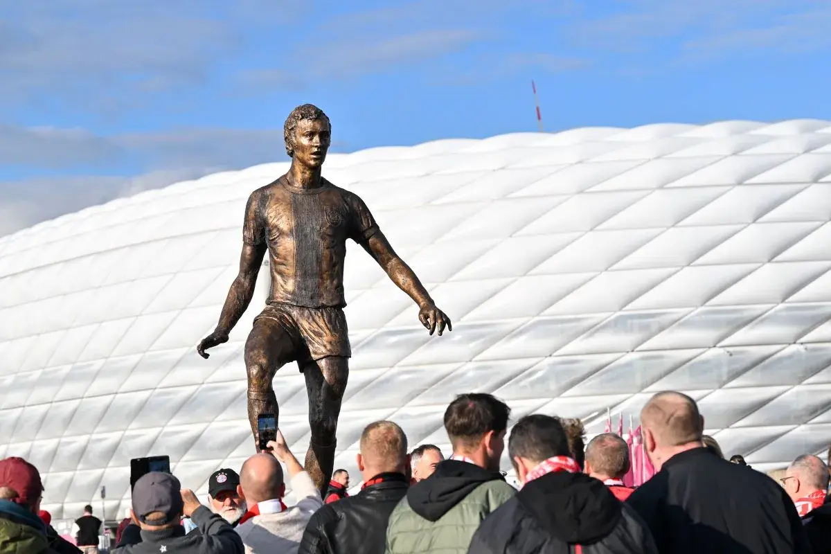 Pomnik piłkarza z Monachium przed stadionem. Fani robią zdjęcia.
