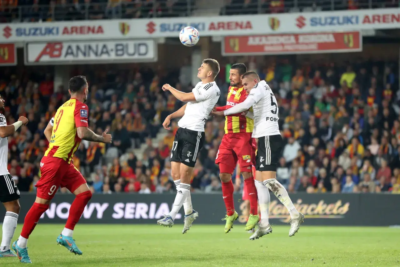 Piłkarze walczą o piłkę w powietrzu. Emocje na boisku, jak podczas ważnych ekstraklasa transfery.