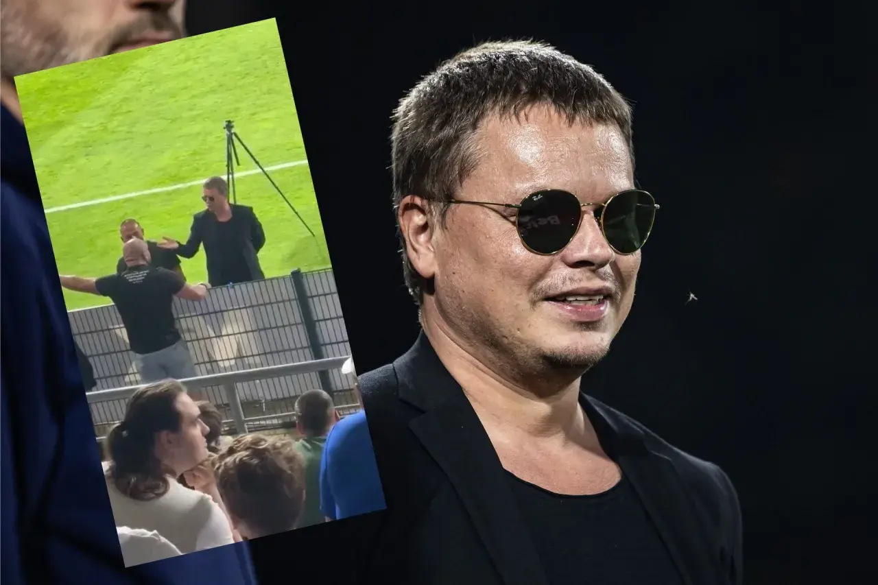 Właściciel Wisły Kraków w okularach przeciwsłonecznych, na tle fragmentu stadionu i kibiców.