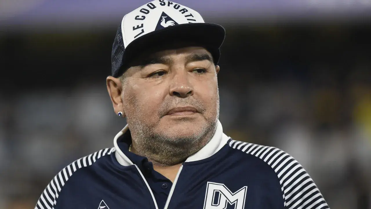 Diego Maradona na co zmarł? Ikona futbolu w czapce z daszkiem i sportowej kurtce.