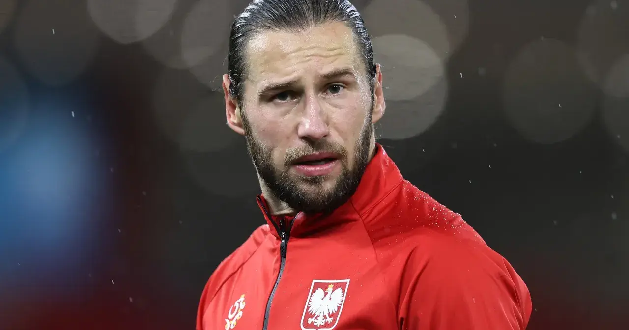 Piłkarz w czerwonej bluzie z orłem na piersi, w deszczu. Krychowiak gdzie gra? Na boisku, w barwach narodowych.