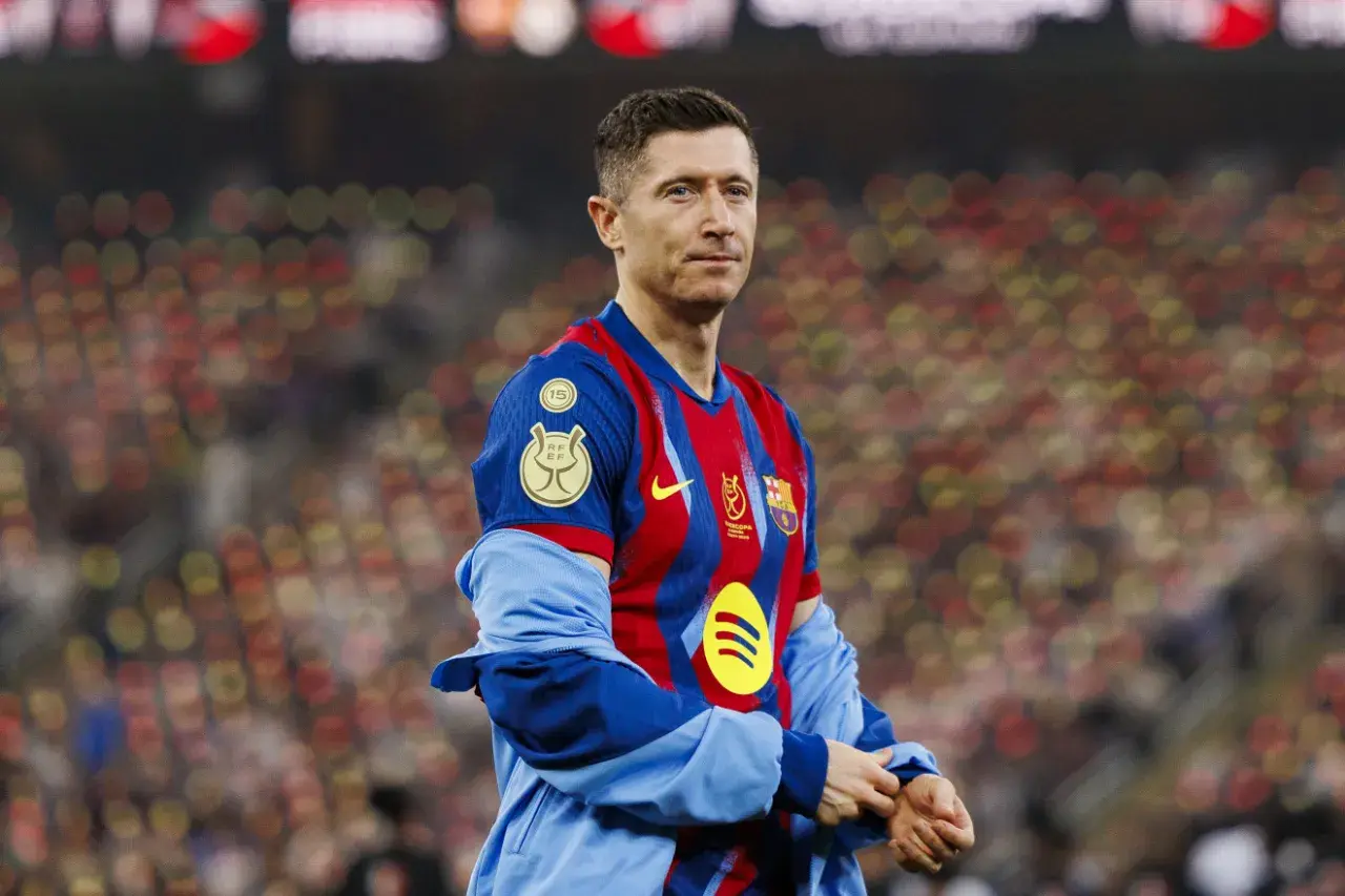 Robert Lewandowski, jeden z najlepiej zarabiających piłkarzy, w koszulce FC Barcelony na tle rozmazanych trybun.