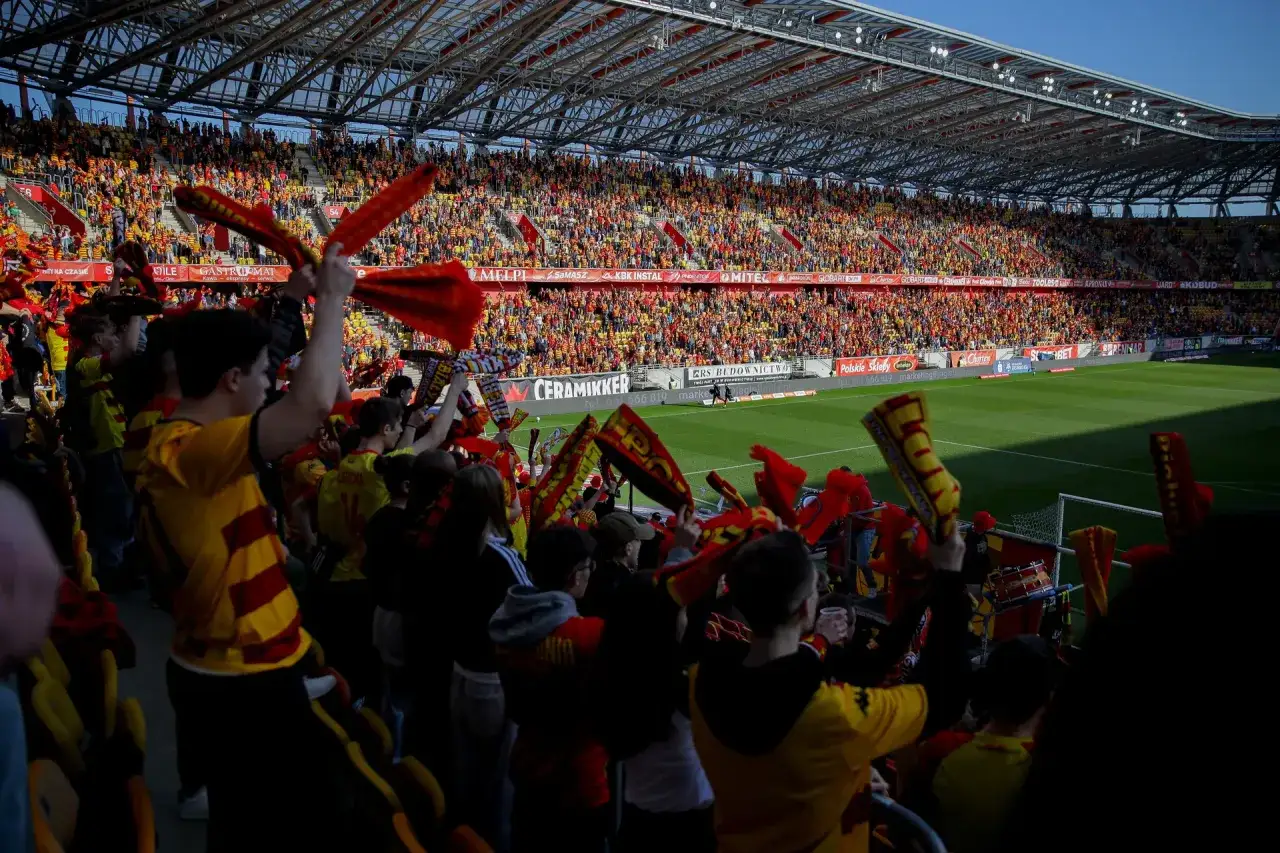 Tłum kibiców na stadionie, machający szalikami w barwach żółto-czerwonych. Wszyscy czekają na rozstrzygnięcie, ile kolejek do końca ekstraklasy.