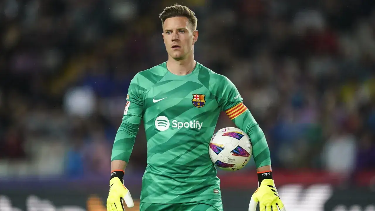 Kapitan Barcelony, Marc-André ter Stegen, w zielonej koszulce bramkarskiej z piłką w ręku.
