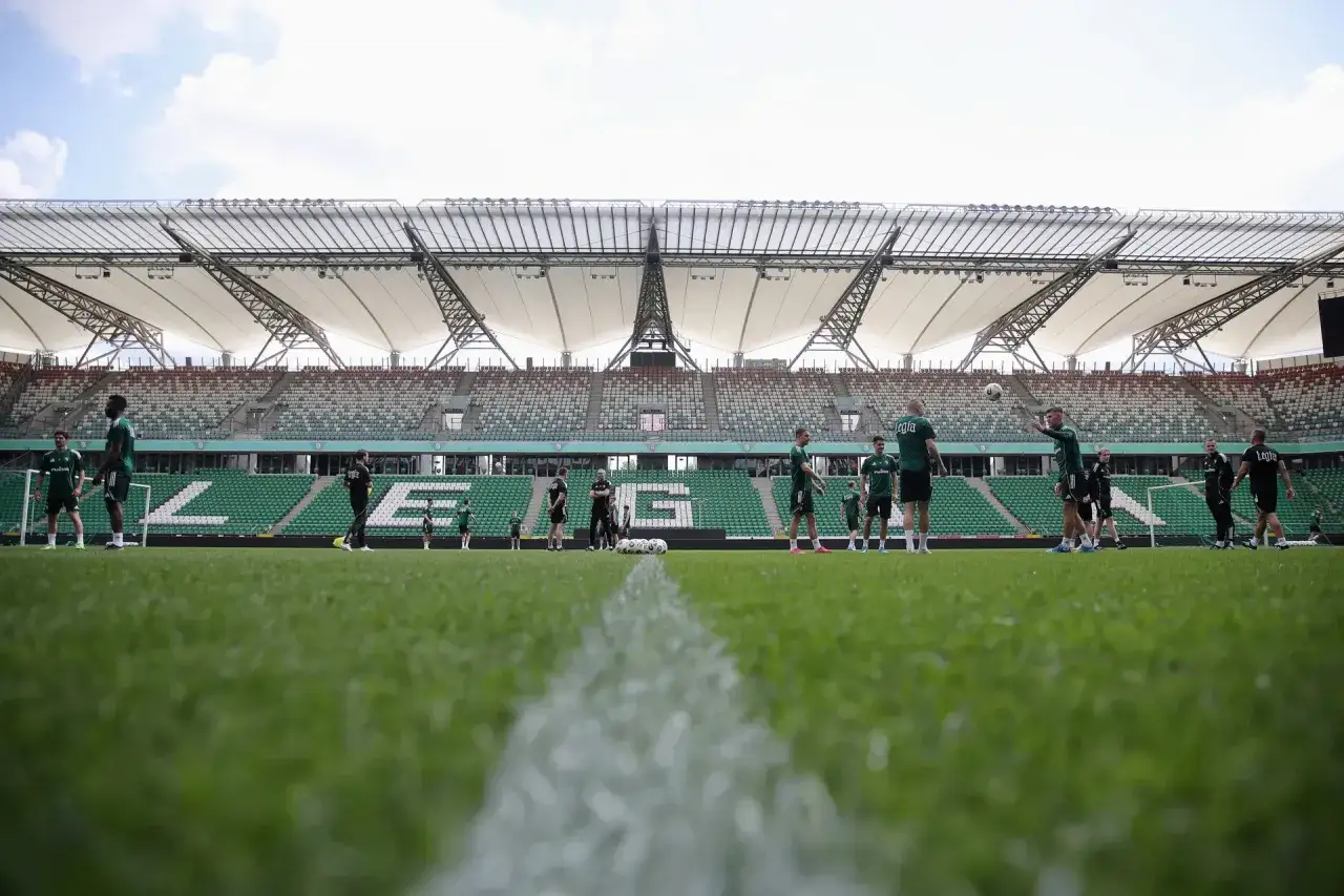 Piłkarze Legii na treningu. W tle trybuny stadionu, a na murawie piłki, jakby szykowano się do kolejnych transferów.