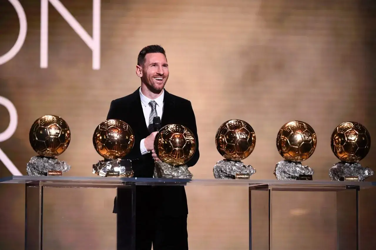 Uśmiechnięty Messi prezentuje swoje liczne złote piłki. Ile złotych piłek ma Messi? Aż osiem!
