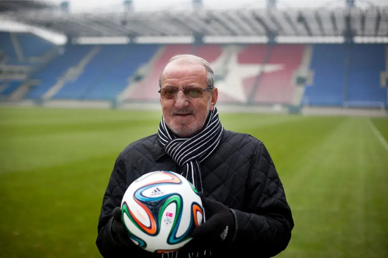Wojciech Kwiecień, z piłką w rękach, na tle stadionu. Jego majątek to lata doświadczeń i pasji do futbolu.