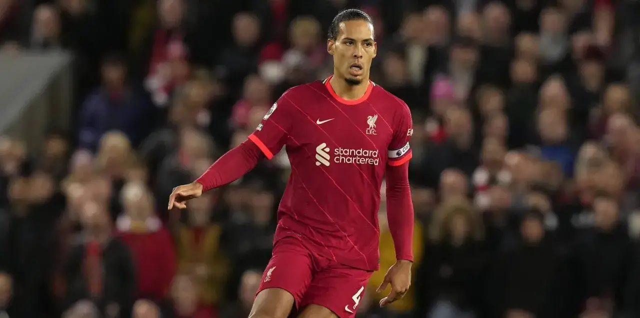 Virgil van Dijk, obrońca na boisku, w czerwonej koszulce Liverpoolu, skupiony na grze.